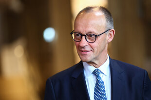 Ein Mann mit Brille schaut freundlich