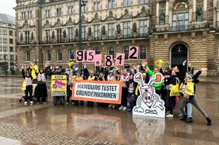 Vertreter der Volksinitiative "Hamburg testet Grundeinkommen" jubeln auf dem Hamburger Rathausmarkt über 95.842 gesammelte Unterschriften.