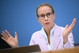 Die Juristin sitzt Fraue Brosius-Gersdorf vor blauem Hintergrund.