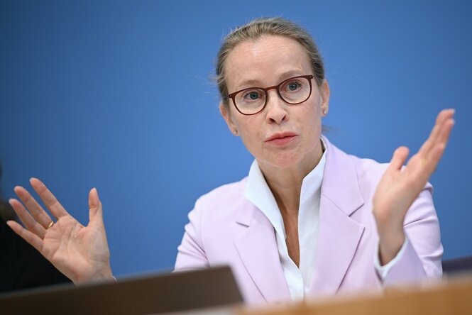 Die Juristin sitzt Fraue Brosius-Gersdorf vor blauem Hintergrund.