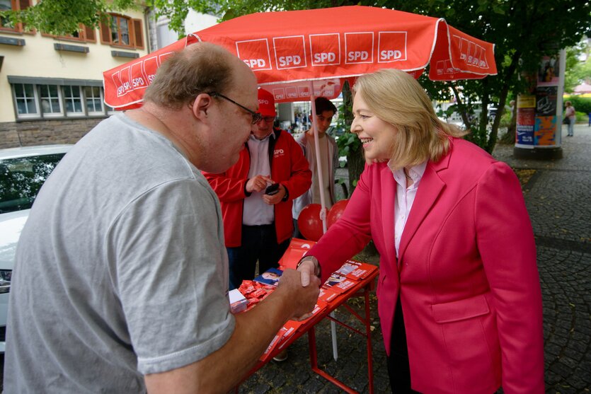 Bärbel Bas unterhält sich vor einem Wahlkampfstand der SPD mit einem Mann