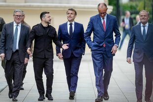 Fünf weiße Männer laufen durch einen Garten