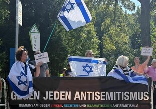 Demonstration mit vielen Israelfahnen und einem Banner, auf dem steht: "Gegen jeden Antisemitismus"