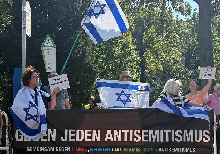 Demonstration mit vielen Israelfahnen und einem Banner, auf dem steht: "Gegen jeden Antisemitismus"