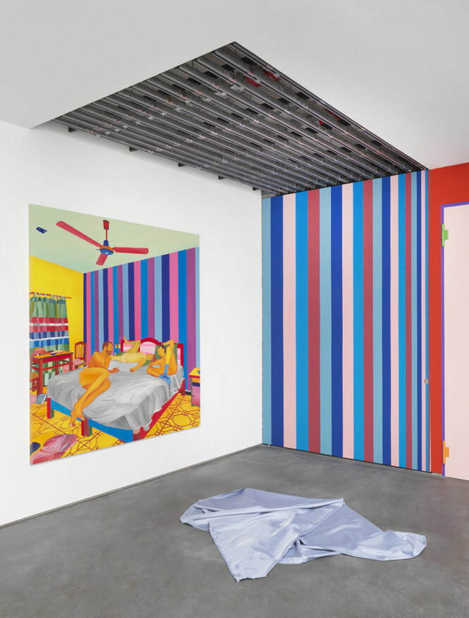 Eine Installationsansicht in der Galerie, ein Duschvorhang liegt auf dem Boden an der Wand hängt ein Bild in grellen Farben