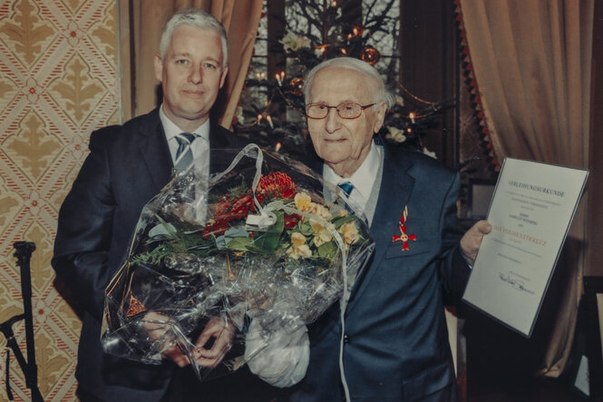 Foto der feierlichen Übergabe des Bundesverdienstkreuzes an Albrecht Weinberg.