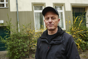 Portraitfoto des Labelgründers Arne Gesemann vor einem Strauch gelber Forsythien