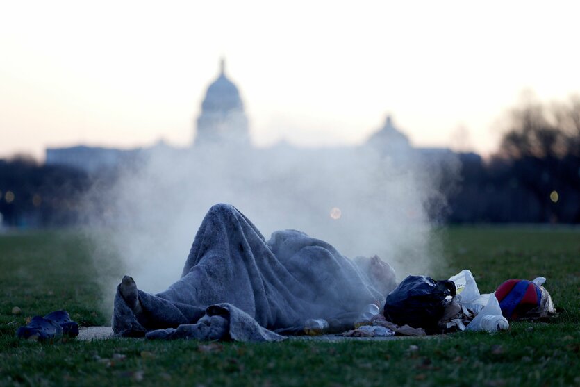 Obdachlose Person liegt auf der Wiese