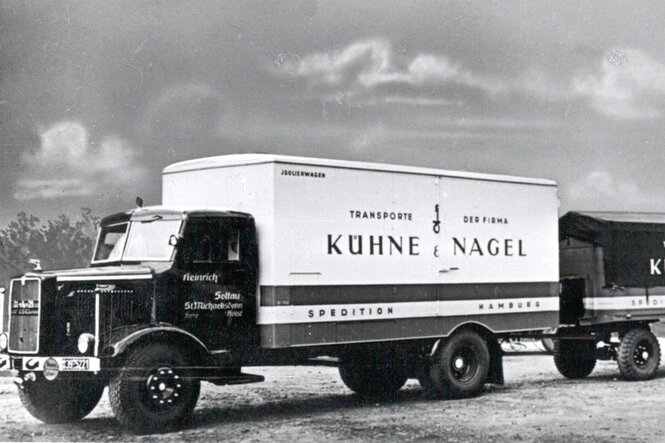 Historische Aufnahme von LKWs.