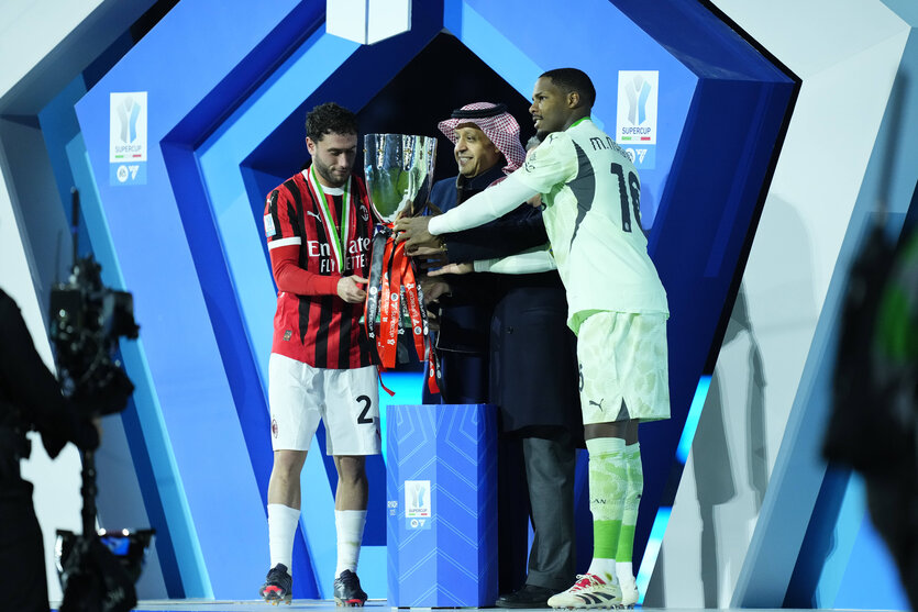 Ein Funktionär in saudischer Tracht bei der Übergane des Pokals an zwei Mailänder Spieler