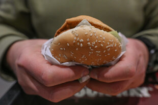 Zwei Hände halten einen Burger