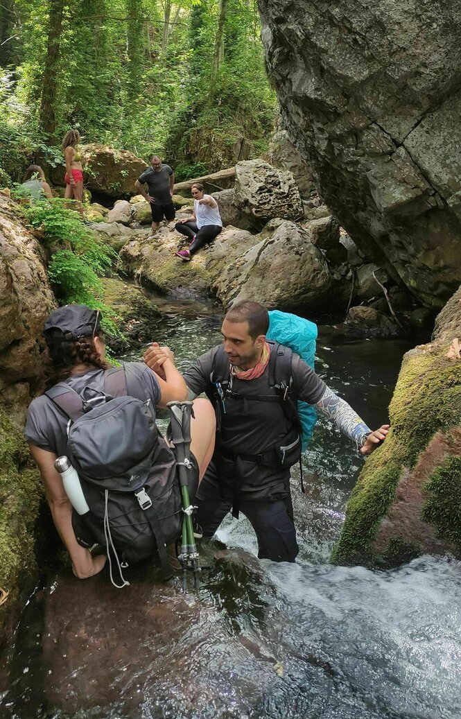 Eine Wandergruppe durchquert schmalen einen Fluss