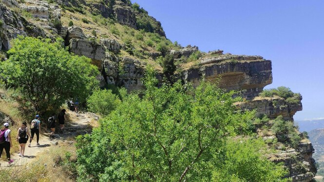 Eine Wandergruppe läuft einen Pfad in den Bergen entlang