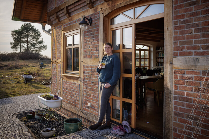 Porträt der Bäuerin Maria Mundry vor ihrem Haus.