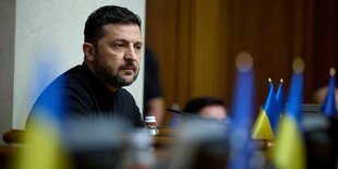 Selenskyj, im Vordergrund ukrainische Fahnen
