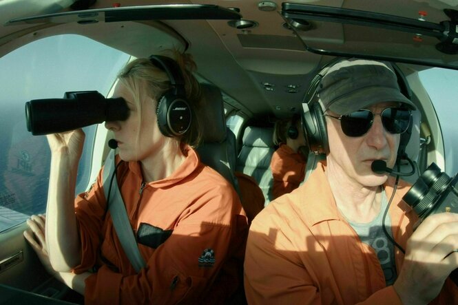 Mann und Frau im Flugzeug mit Ferngläsern
