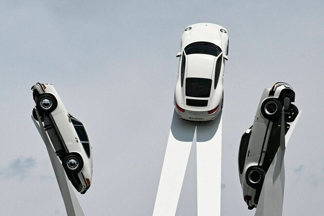 Drei Porsches streben himmelwärts auf einer Kunstinstallation