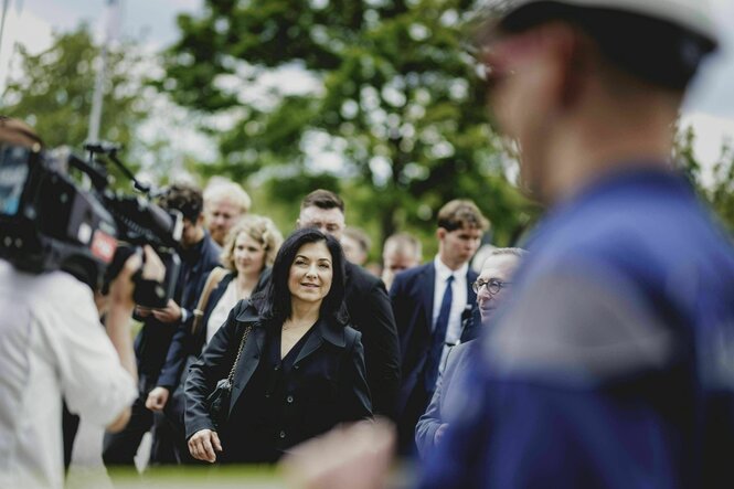 Eine Frau umgeben von Vertreter:innen der Presse