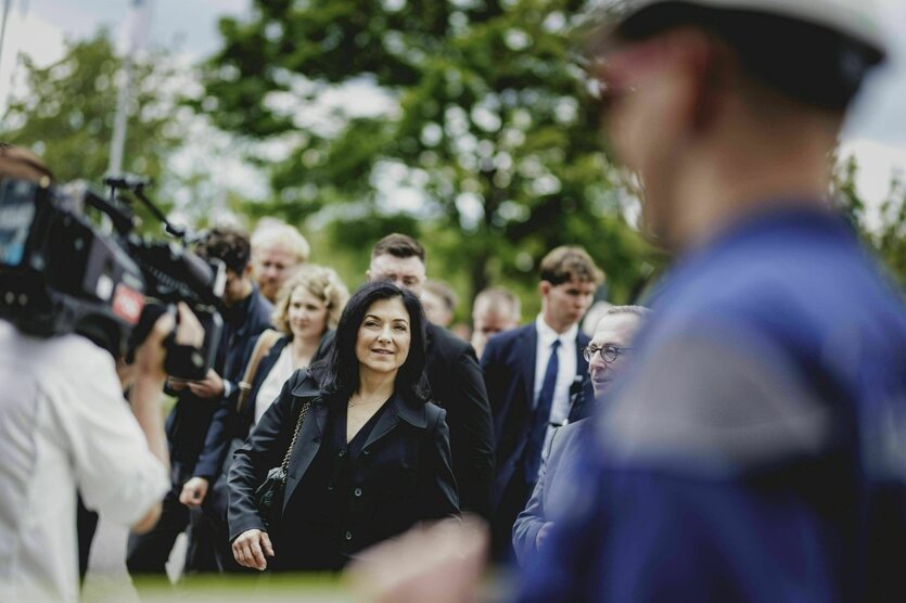 Eine Frau umgeben von Vertreter:innen der Presse