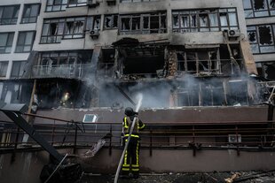 Ukrainischer Feuerwehrmann löscht das Feuer in einem Wohnblock nach einem nächtlichen Drohnenangriff