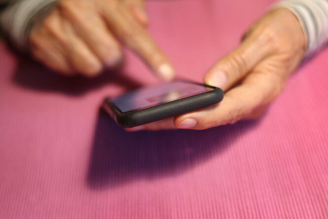 Eine Frau tippt auf einem iPhone.