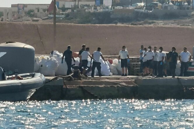 Beamte der italienischen Küstenwache tragen einen Leichensack auf dem Dock des Hafens von Lampedusa