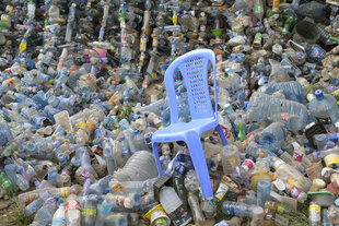 Ein Plastikgartenstuhl in einem Plastikflaschenmeer