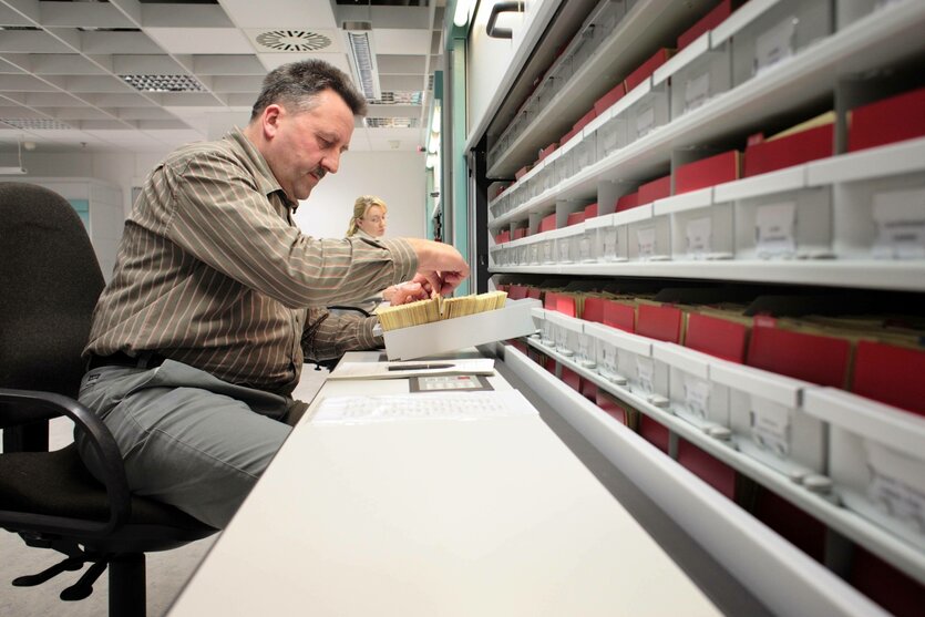 Archiv der Stasi-Unterlagenbehoerde, ein Mann blättert in einer Kartei