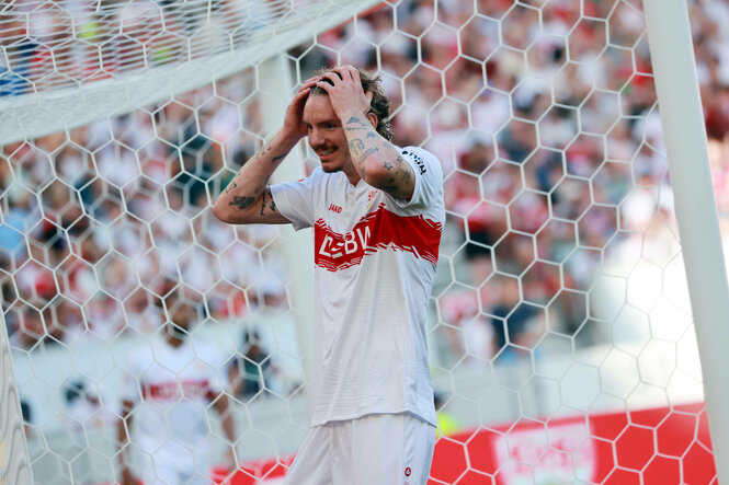 Ein Fußballspieler im VfB-Stuttgart-Trikot steht vor dem Tor und fährt sich durch die Haare