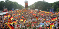 Fans der deutschen Fußball-Nationalmannschaft schwenken Fahnen während der Fußball-WM 2006 beim Fan-Fest in Berlin