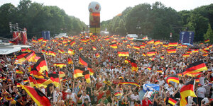 Fans der deutschen Fußball-Nationalmannschaft schwenken Fahnen während der Fußball-WM 2006 beim Fan-Fest in Berlin