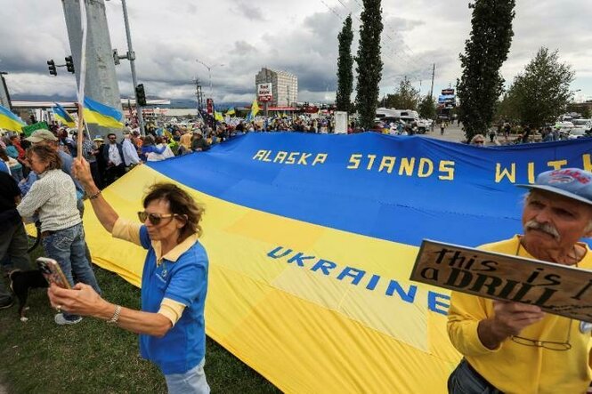 Demonstranten mit einer großen Flagge der Ukraine
