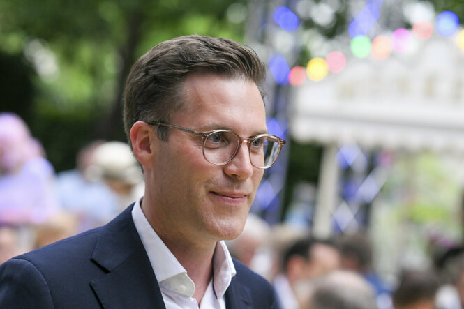 Ein Mann mit Brille schaut zufrieden
