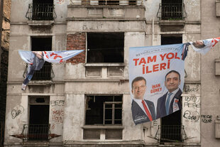Zwei Männer sind auf einem Wahlkampf-Banner zu sehen, das an einer Hausfassade hängt