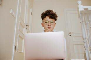 Ein Teenager sitzt vor einem Laptop