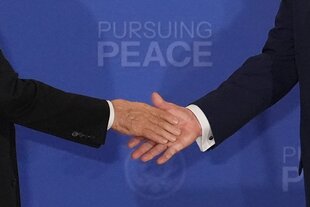 Trump und Putin schütteln sich die Hände. Man sieht nur die Hände und Arme der beiden Staatsmänner