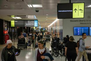 Flughafen Newark: Zu sehen sind Wegweiser, Menschen und ein Rollstuhl