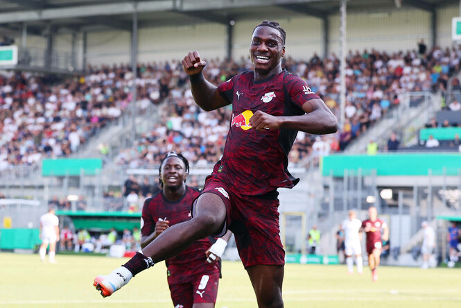 Ein Fußballspieler im RB Leipzig-Trikot springt glücklich in die Luft