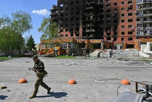 Ein Soldat auf einer Straße vor einem zerstörten Wohnblock