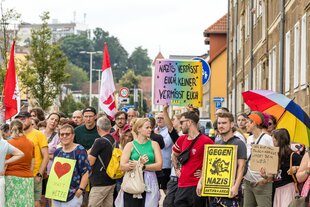 Menschen in Spremberg tragen Plakate mit Aufschriften wie «Nazis verpisst euch, keiner vermisst euch»