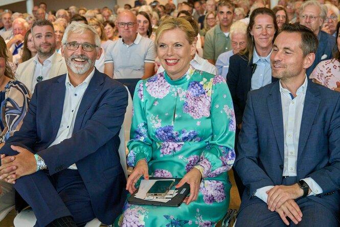 Klöckner sitzt zwischen zwei Männern