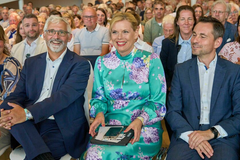 Klöckner sitzt zwischen zwei Männern