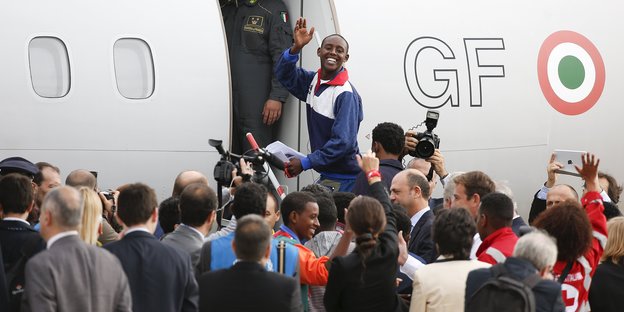 Ein Flüchtling wird in Rom in ein Flugzeug nach Schweden begleitet.