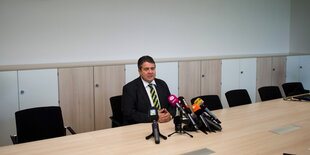 Sigmar Gabriel sitzt an einem leeren Tisch