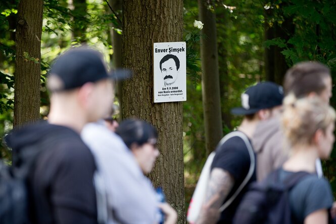Ein Portrait des ersten NSU-Opfers Enver Simsek hängt an einem Baum nahe des Tatorts