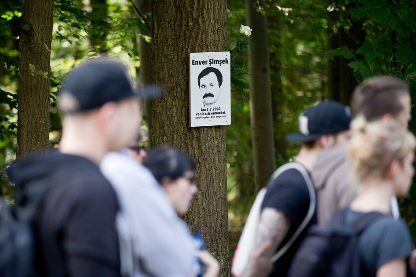 Ein Portrait des ersten NSU-Opfers Enver Simsek hängt an einem Baum nahe des Tatorts