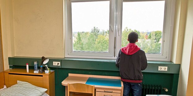 Flüchtling am Fenster einer Unterkunft