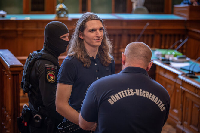 Maja T. in einem ungarischen Gerichtssaal unter der Beobachtung zweier Beamter.