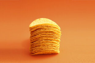 Ein Stapel Chips vor orangenem Hintergrund