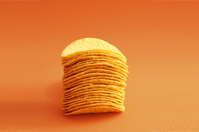 Ein Stapel Chips vor orangenem Hintergrund